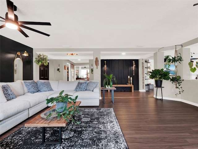 living room featuring ceiling fan and dark hardwood / wood-style floors