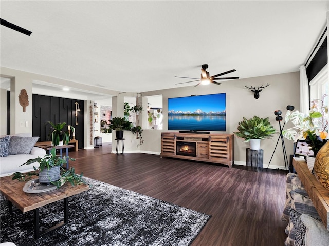 living room with hardwood / wood-style flooring, ceiling fan, and a fireplace