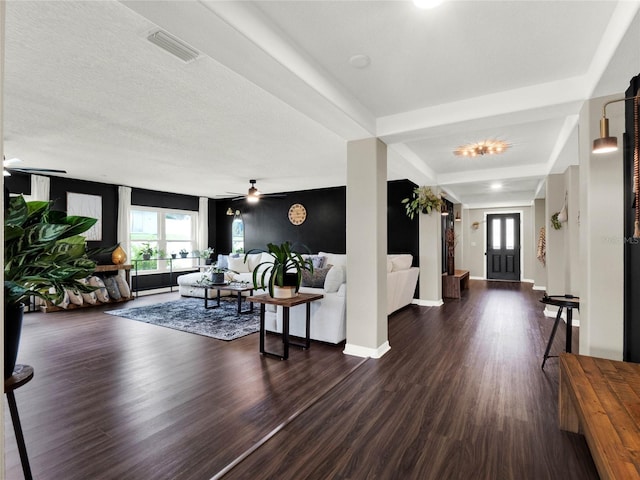 living room featuring ceiling fan, dark hardwood / wood-style flooring, and a textured ceiling