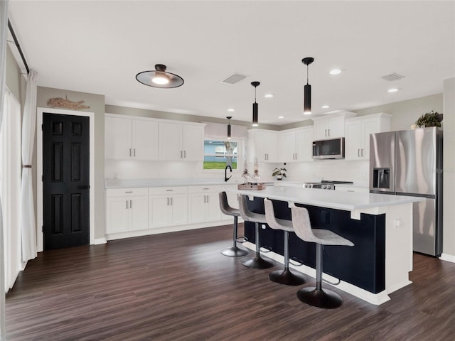 kitchen with white cabinetry, a breakfast bar area, hanging light fixtures, a center island, and stainless steel refrigerator with ice dispenser