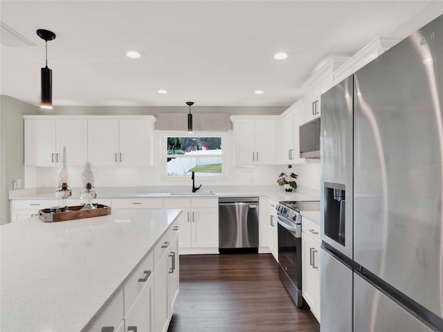 kitchen with sink, white cabinetry, hanging light fixtures, dark hardwood / wood-style floors, and stainless steel appliances