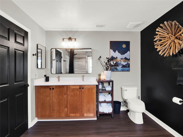 bathroom with hardwood / wood-style flooring, vanity, a textured ceiling, and toilet