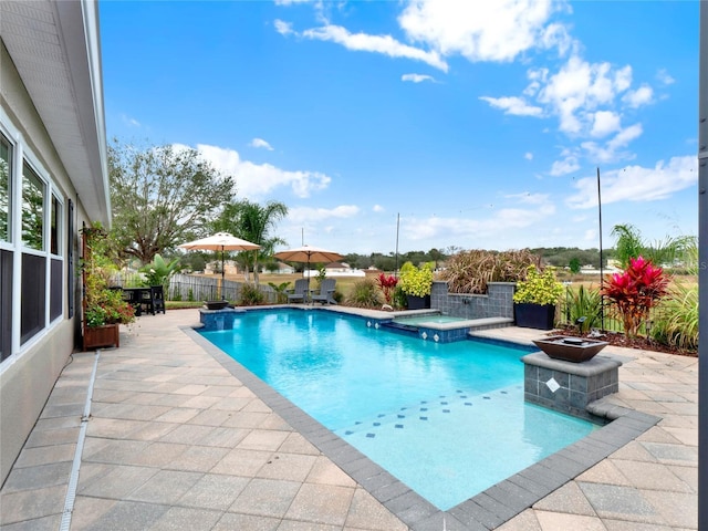 view of swimming pool featuring a patio area and an in ground hot tub