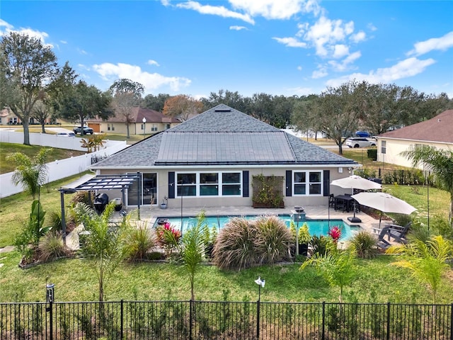 rear view of house with a fenced in pool, a pergola, a patio area, and a lawn