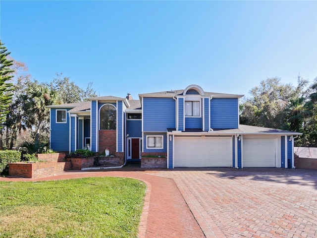 view of front of house with a garage and a front lawn