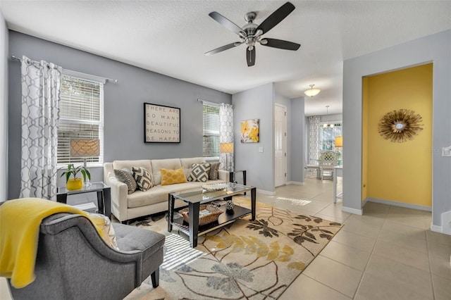 tiled living room featuring ceiling fan, a wealth of natural light, and a textured ceiling