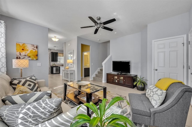 living room featuring light tile patterned floors, a textured ceiling, and ceiling fan