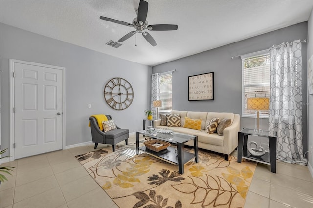 living room with light tile patterned floors, a textured ceiling, and ceiling fan