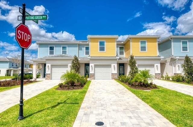 multi unit property featuring a garage and a front yard