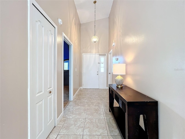 doorway featuring a high ceiling and light tile patterned flooring