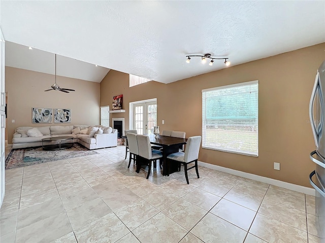 dining area with french doors, light tile patterned flooring, vaulted ceiling, a textured ceiling, and ceiling fan