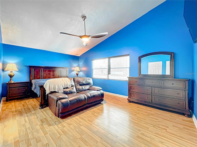 bedroom featuring vaulted ceiling, ceiling fan, light hardwood / wood-style floors, and a textured ceiling