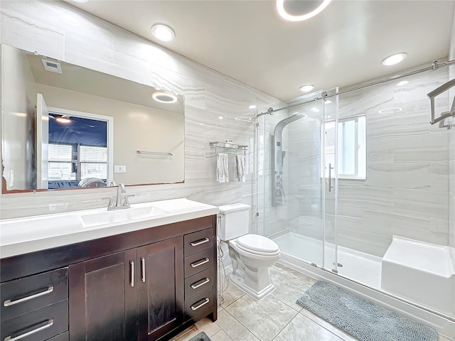 bathroom with tile walls, an enclosed shower, vanity, a wealth of natural light, and toilet