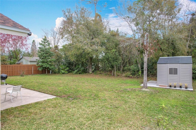 view of yard featuring a shed and a patio area