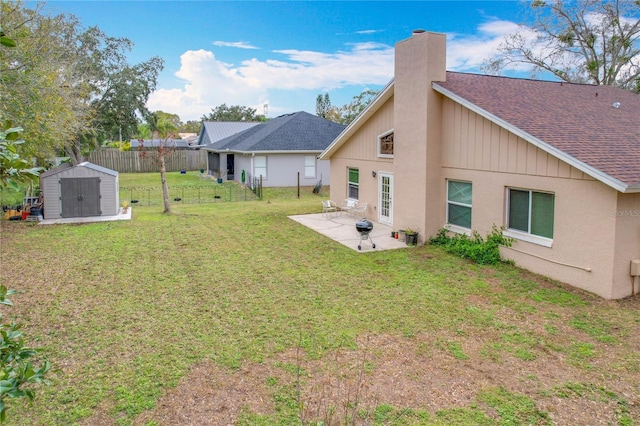 back of house featuring a storage shed, a yard, and a patio