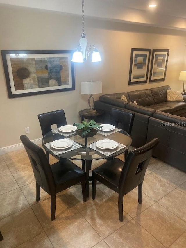 dining area with a chandelier, light tile patterned floors, and baseboards