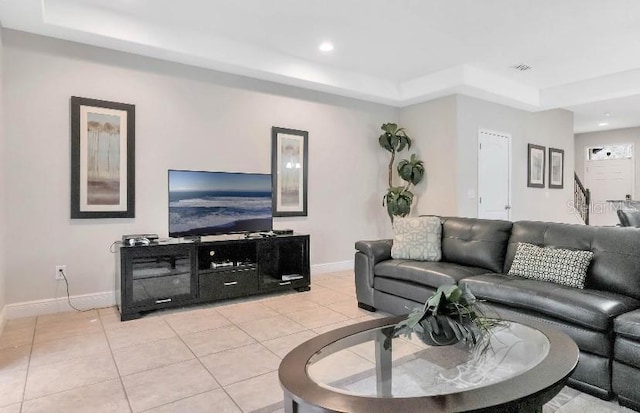 living room with light tile patterned floors, baseboards, a raised ceiling, and recessed lighting