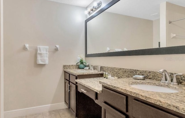 full bath with tile patterned flooring, vanity, and baseboards