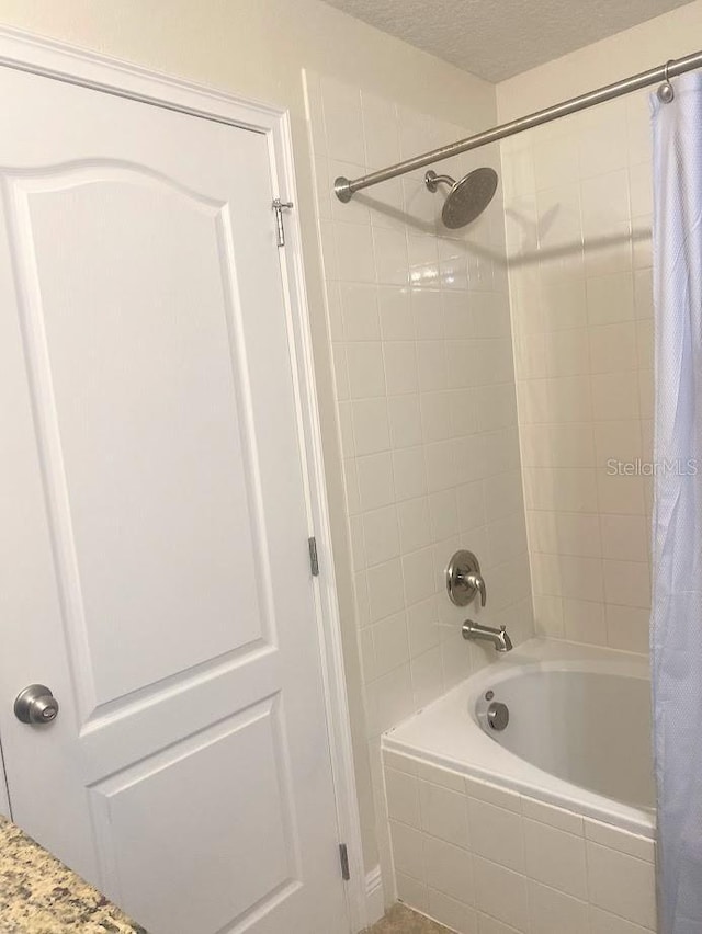 full bathroom featuring a textured ceiling and shower / bath combo with shower curtain