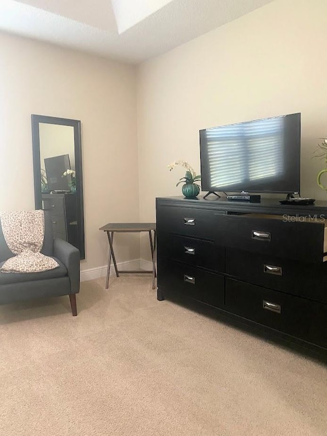 sitting room featuring baseboards and light colored carpet