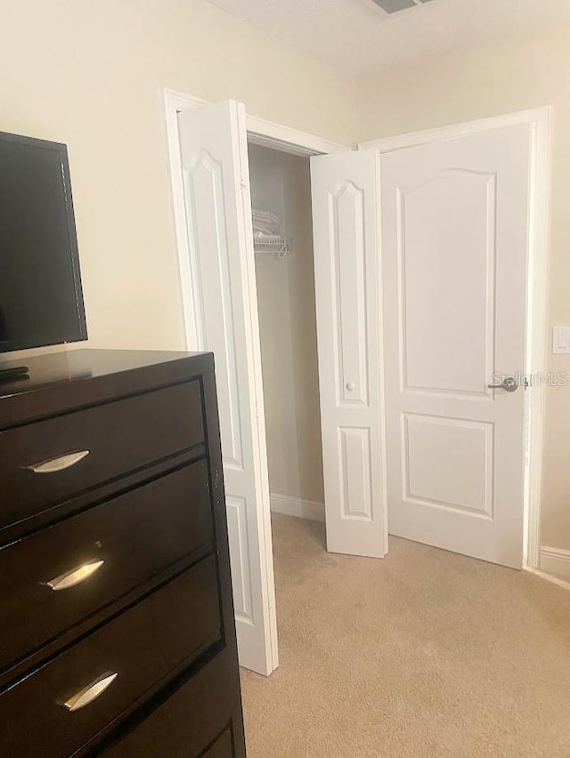 unfurnished bedroom featuring a closet and light carpet