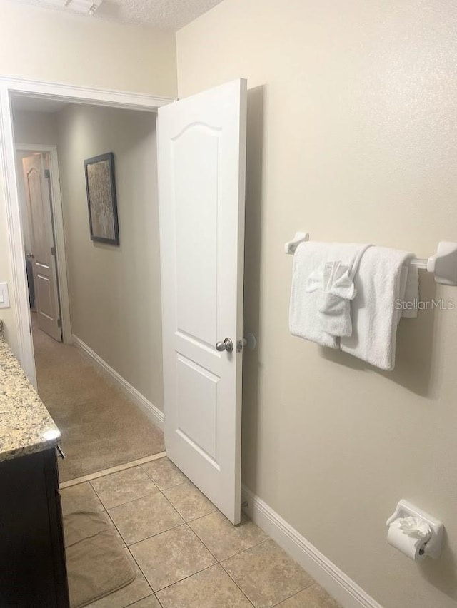 bathroom featuring tile patterned floors, vanity, and baseboards