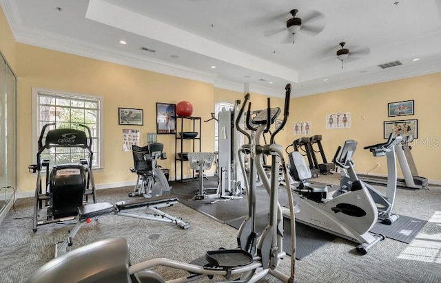 gym featuring ornamental molding, a tray ceiling, visible vents, and baseboards