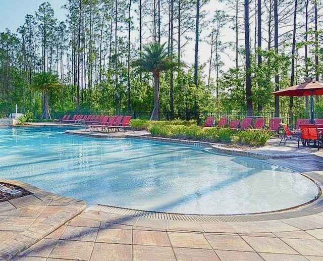 community pool featuring a patio area and fence