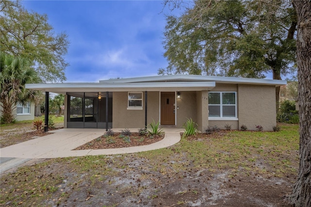 view of front facade featuring driveway, an attached carport, and stucco siding