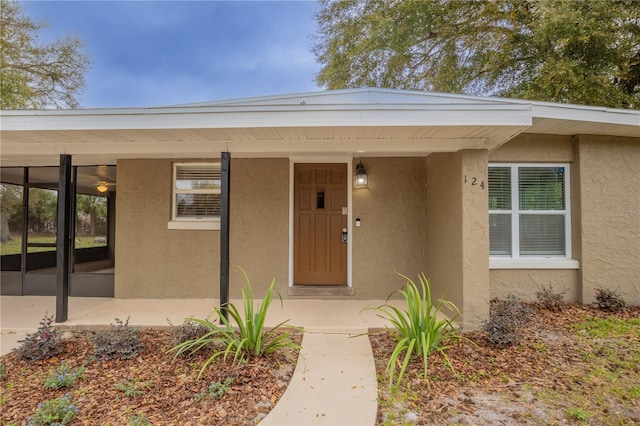 view of exterior entry featuring stucco siding