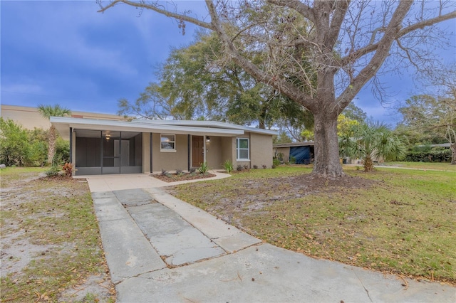 single story home with a carport, a front yard, driveway, and stucco siding