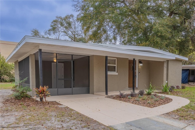 view of front of home featuring a sunroom and stucco siding