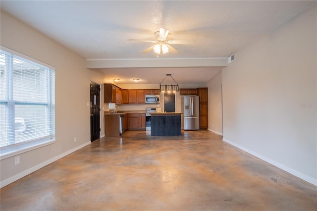 kitchen featuring brown cabinets, light countertops, hanging light fixtures, appliances with stainless steel finishes, and baseboards