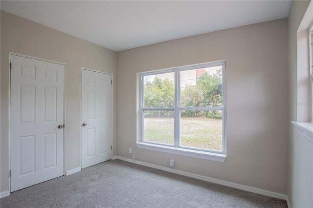 unfurnished bedroom featuring baseboards and light colored carpet