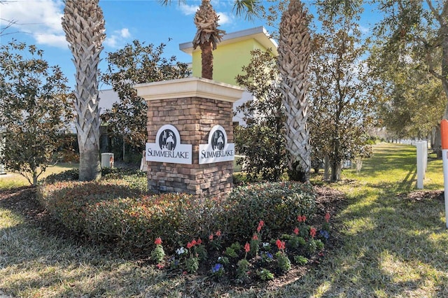 community / neighborhood sign featuring a yard