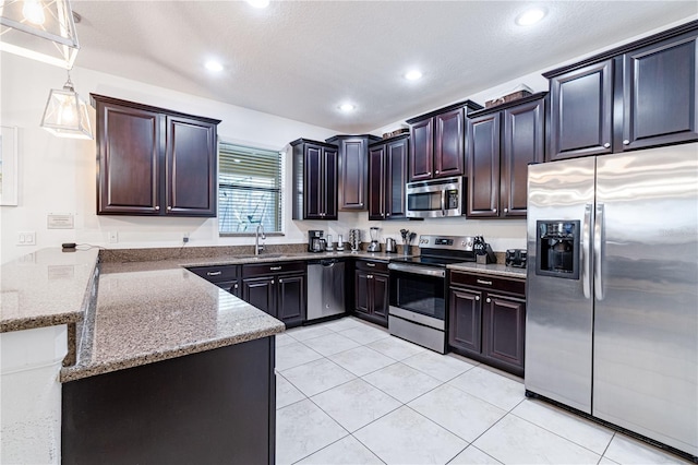 kitchen featuring appliances with stainless steel finishes, stone countertops, sink, hanging light fixtures, and light tile patterned floors