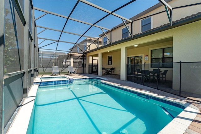 view of swimming pool with an in ground hot tub, a lanai, and a patio