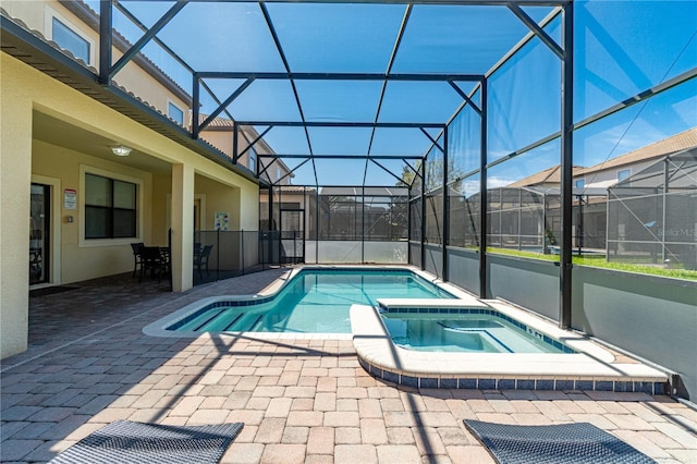 view of swimming pool with a lanai, a patio, and an in ground hot tub