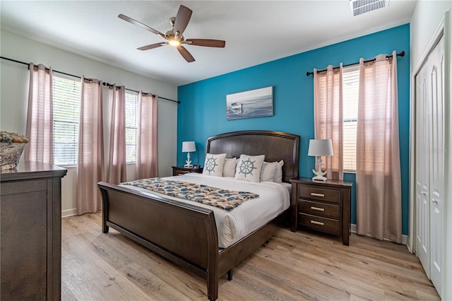 bedroom with ceiling fan, a closet, and light wood-type flooring