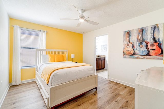 bedroom with ceiling fan, connected bathroom, a textured ceiling, and light hardwood / wood-style floors