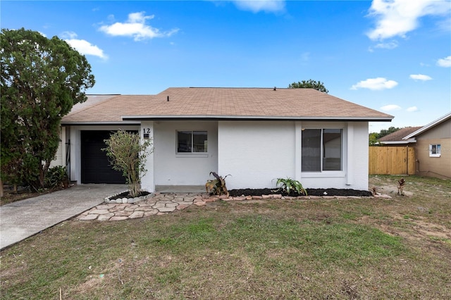 back of property with a garage and a lawn