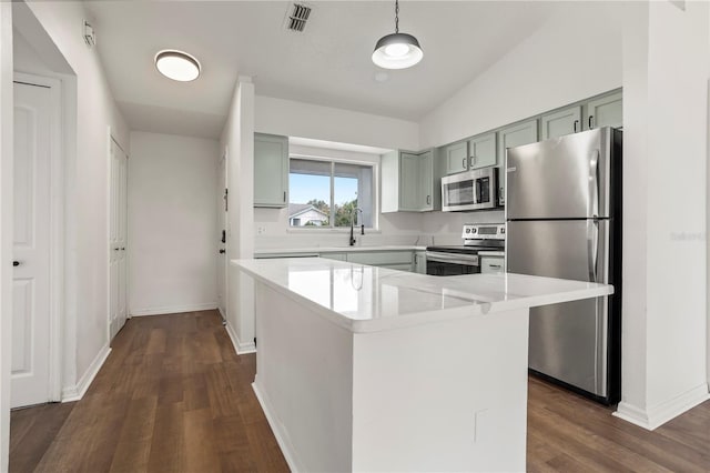 kitchen with dark wood-type flooring, lofted ceiling, a center island, pendant lighting, and stainless steel appliances