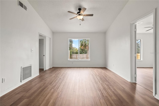 unfurnished room with plenty of natural light, dark hardwood / wood-style floors, and ceiling fan