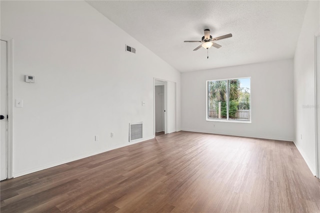 empty room with lofted ceiling, a textured ceiling, dark hardwood / wood-style floors, and ceiling fan