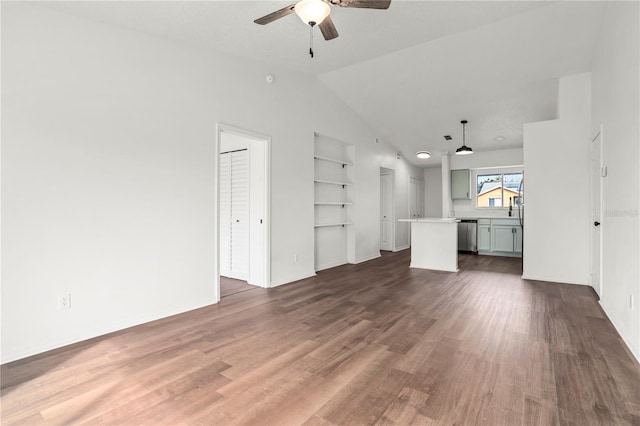 unfurnished living room with built in shelves, dark wood-type flooring, ceiling fan, and vaulted ceiling