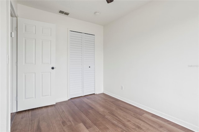 unfurnished bedroom featuring hardwood / wood-style floors and a closet