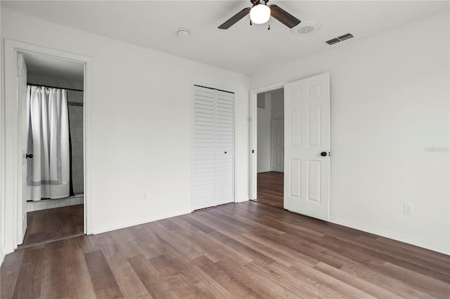 unfurnished bedroom featuring hardwood / wood-style flooring, ceiling fan, and a closet