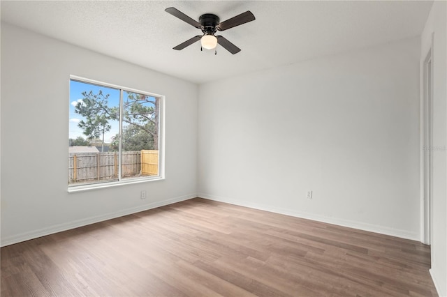 spare room with hardwood / wood-style flooring, ceiling fan, and a textured ceiling