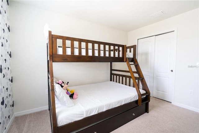 bedroom featuring light colored carpet and a closet