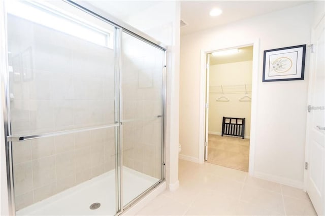 bathroom with a shower with shower door, tile patterned floors, and toilet